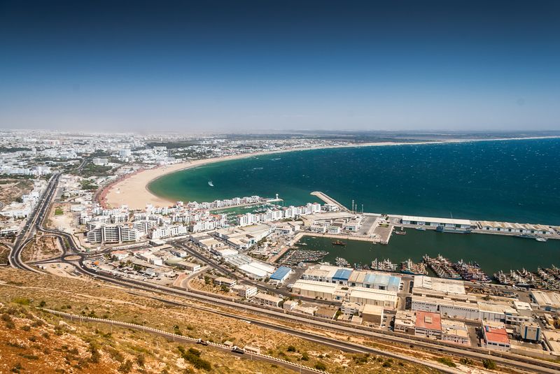 Chauffeur professionnel accueillant un client avec une pancarte nominative à l'aéroport de Marrakech