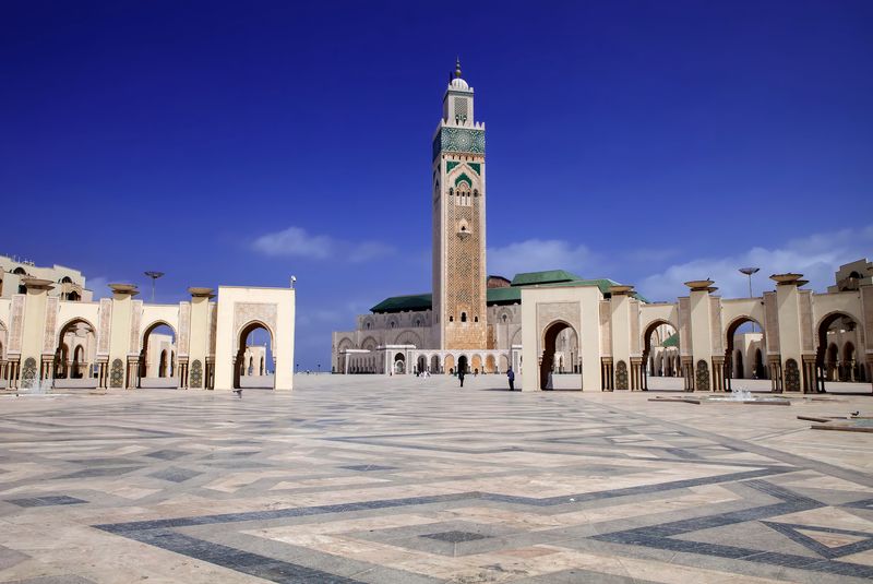 Chauffeur professionnel accueillant un client avec une pancarte nominative à l'aéroport de Marrakech